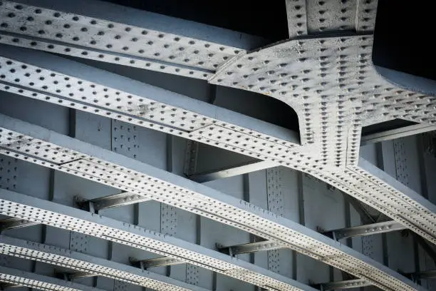 Photo of Steel beams on a railway bridge with steel plates and riveted connections.