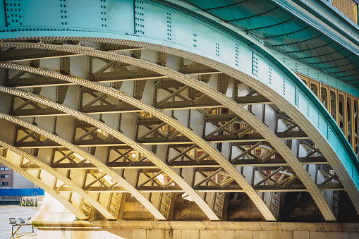 Steel beams on a railway bridge with steel plates and riveted connections. Landscape format.