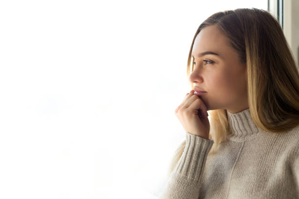 Young woman looking through the window