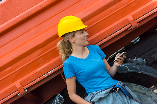 Female construction worker using smartphone