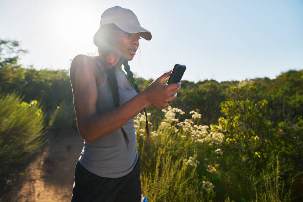 istock woman taking a break to look at smartphone while hiking 928548874