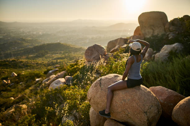 istock fit female hiker sitting on rock at mountain top relaxing 928549914
