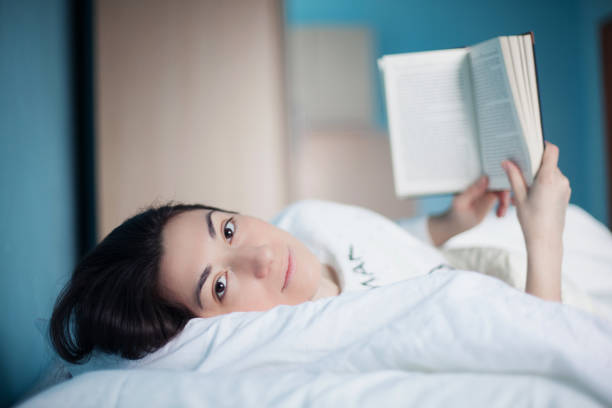 istock Young women in bedroom reading a book 928553832