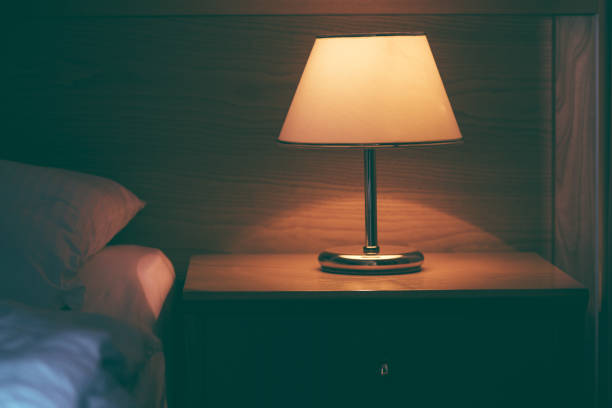 istock Vintage lamp on night table in hotel room 928553920
