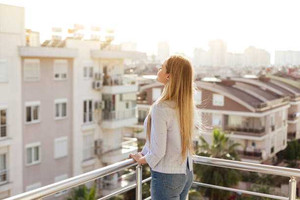 istock Woman standing and relaxing on balcony 928565572