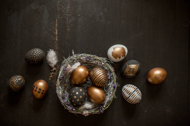 istock Golden decorated easter eggs against black wooden background 928565958