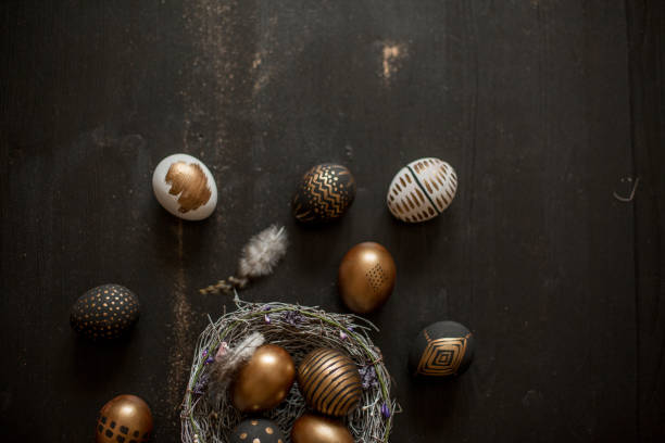istock Golden decorated easter eggs against black wooden background 928566074