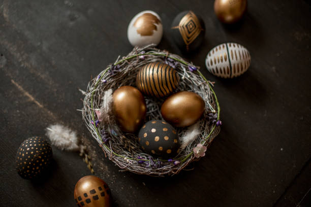 istock Golden decorated easter eggs against black wooden background 928566078