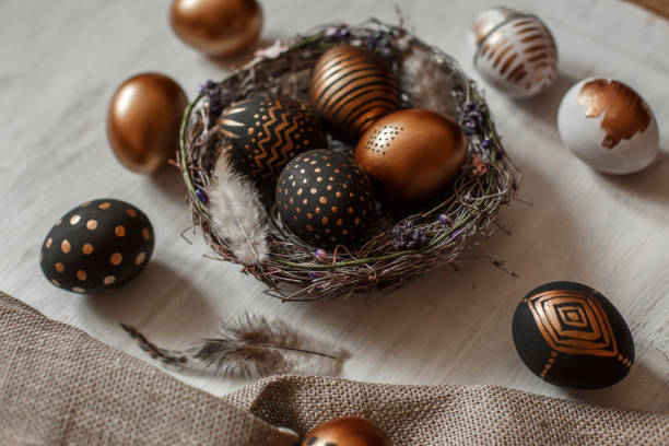 istock Golden decorated easter eggs against white wooden background 928566334