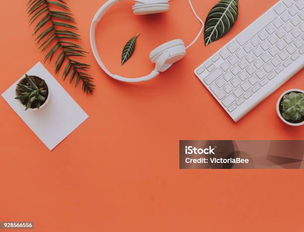 Kreative Wohnung Lag Der Arbeitsbereich Schreibtisch Büromaterial Tastatur Kopfhörer Und Lifestyleobjekten Auf Orangem Hintergrund Mit Textfreiraum Stockfoto und mehr Bilder von Schreibtisch