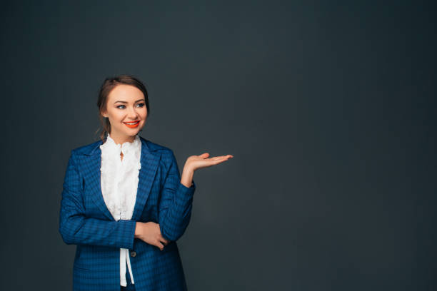 istock business woman pointing copy space and smiling 928566632