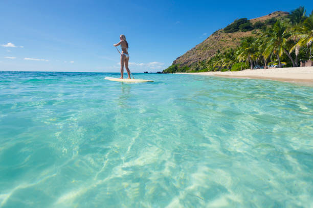 Woman paddling on a stand up paddleboard.