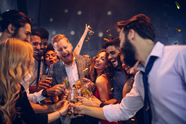Here's to fun and friendship ! Group of friends celebrating at a nightclub office party stock pictures, royalty-free photos & images