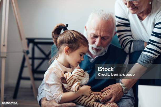 Comfort And Care From Her Grandparents Stock Photo - Download Image Now - Grandparent, Child, Grandfather