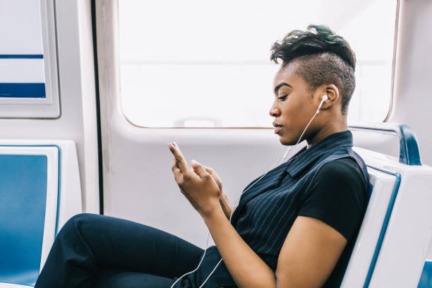 istock hip black businesswoman texting while sitting in the train 928580578