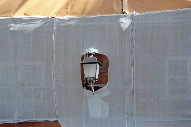 streetlamp behind a torn neting material in a costruction site