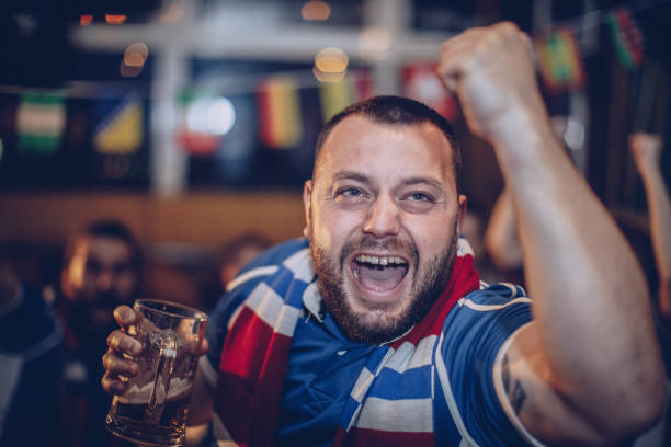 istock Friends drinking beer and watching game in bar 928594416