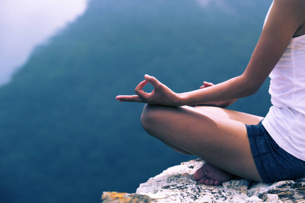 istock One woman practicing yoga at mountain peak 928597026