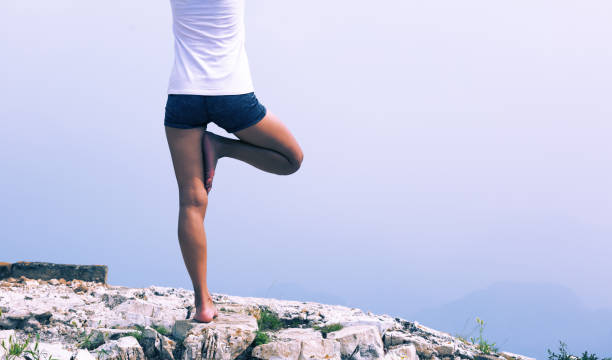 istock One woman practicing yoga at mountain peak 928599014