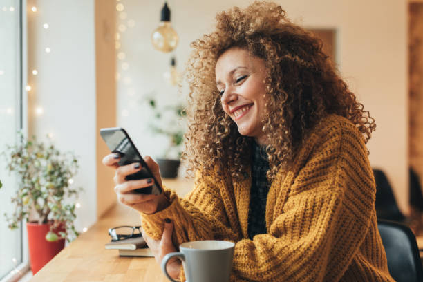 enviar mensajes de texto por una mujer bonita en el teléfono - red hair fotografías e imágenes de stock