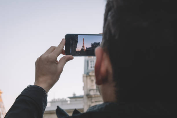 istock Man in front of Eiffel Tower making photograph 928617746