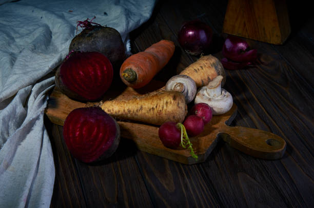 rustic vegetable composition on wooden table. beetroots, celery, carrot, red onion and radish on the cutting board