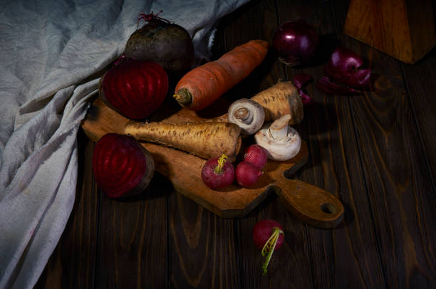 rustic vegetable composition on wooden table. beetroots, celery, carrot, red onion and radish on the cutting board