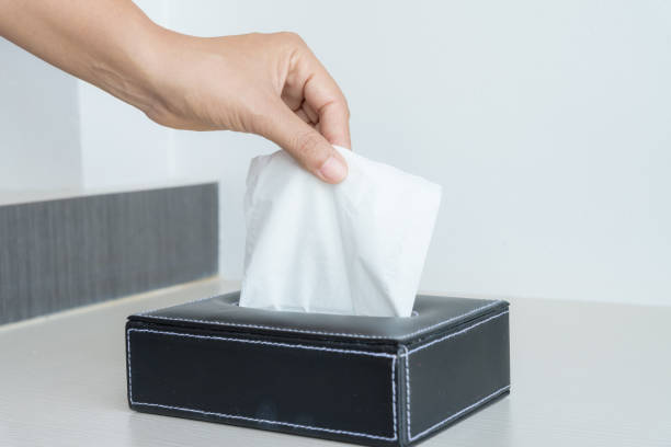 istock Woman hand picking white tissue paper from tissue box. 928630936