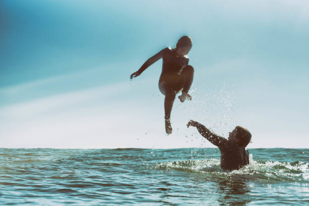 istock Father throwing son in the ocean 928653468