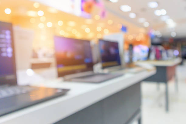 istock Computer notebook laptop on table at electronics store in shopping mall abstract blur defocused background 928695712