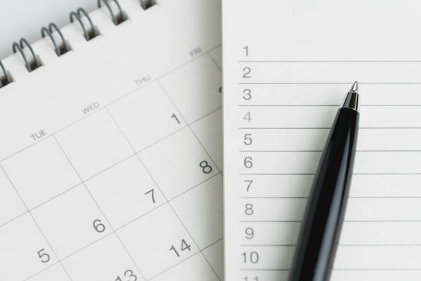 istock Writing to do list or work target plan concept, black pen on notepad with list of numbers on clean desktop flip calendar 928695858