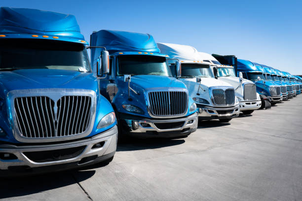 Fleet of blue 18 wheeler semi trucks Large fleet of commercial trucks 18 wheelers parked in truck yard semi truck photos stock pictures, royalty-free photos & images