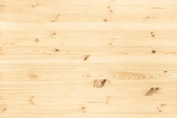 Natural light colored wood texture background viewed from above. Use this clean wooden textured material as graphic design asset for a wall, floor boards, wallpaper, table surface or other furniture.
