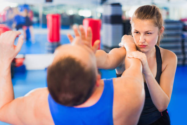 istock Woman is training with man on the self-defense course in gym. 928699330