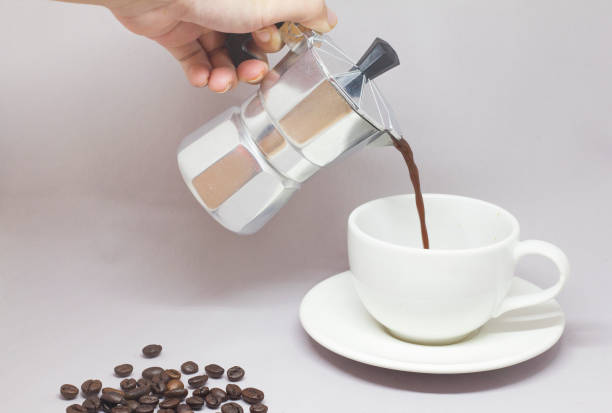 istock Moka pot and pouring coffee on a gray background. 928701626
