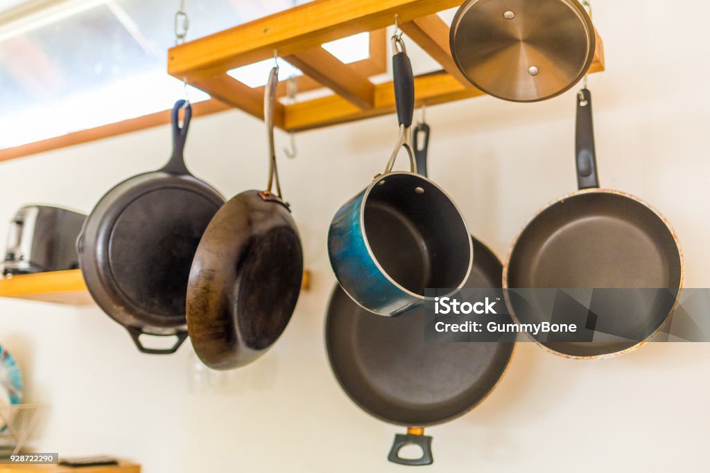 Saucepan and other kitchenware hanging Saucepan and other kitchenware hanging on the wall Breakfast Stock Photo