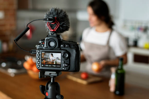 Female vlogger recording cooking related broadcast at home Female vlogger recording cooking related broadcast at home social gathering photos stock pictures, royalty-free photos & images
