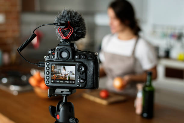 female vlogger recording cooking related broadcast at home - tripod camera photographic equipment photography imagens e fotografias de stock