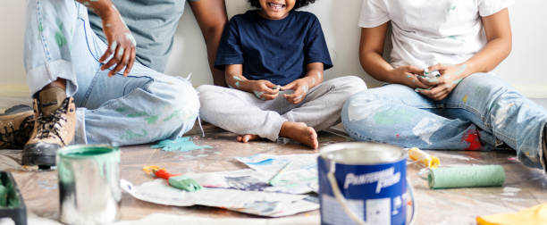istock Black family painting house wall 928726122