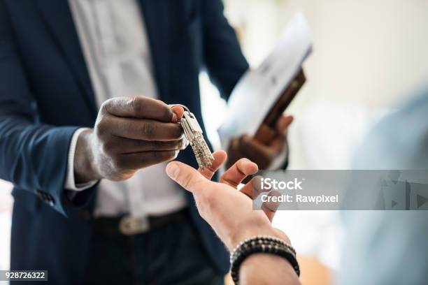 Real Estate Agent Handing The House Key To A Client Stock Photo - Download Image Now