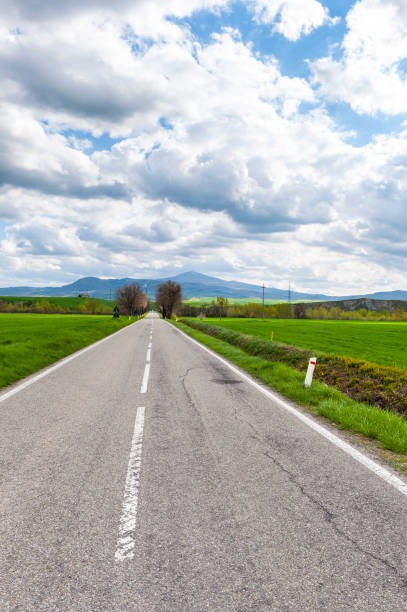istock Asphalt road between meadow in Italy 928741306