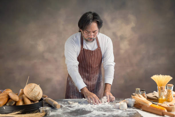 istock Chef hipster stylish kneads dough for bread on wooden board 928744038