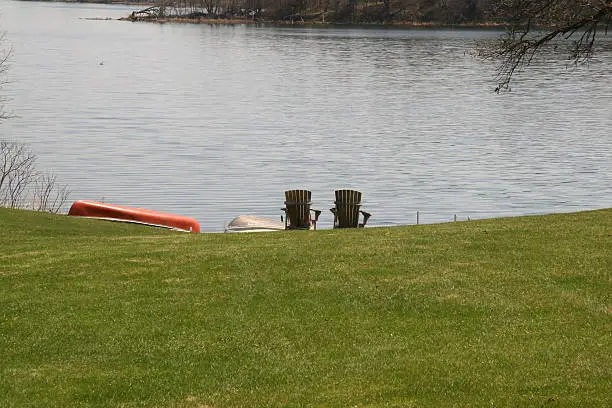 Photo of Canoes and chairs at the lake
