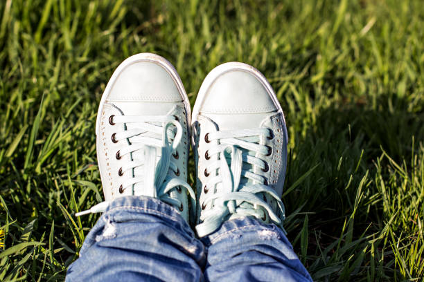 istock Female legs in a clearing with green grass. 928751634