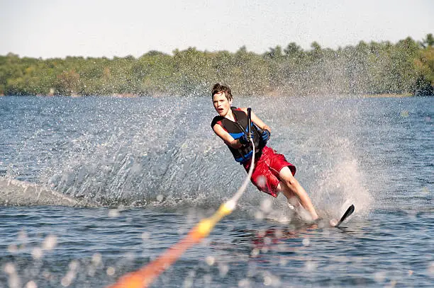 Photo of Teenage boy waterskiing on a lake
