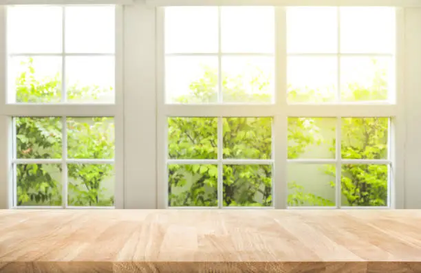 Photo of Top of wood table counter on blur window view garden background.