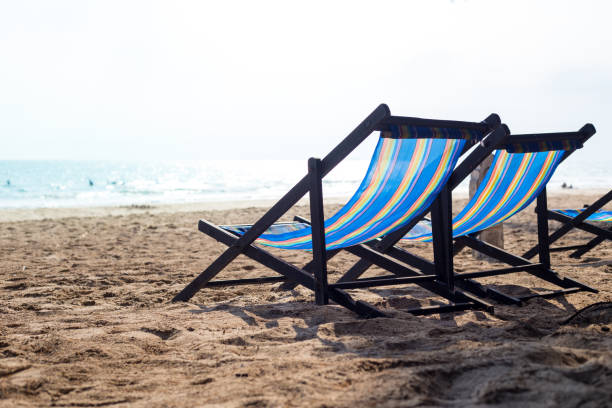 istock Two beach chair on the beach at sunset. 928765440