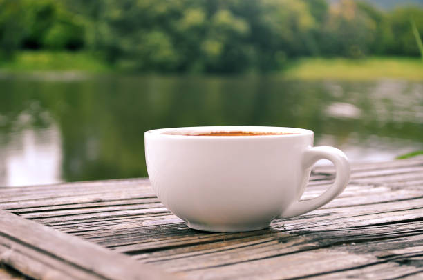 istock Coffee on wooden table and nature view background. 928765598