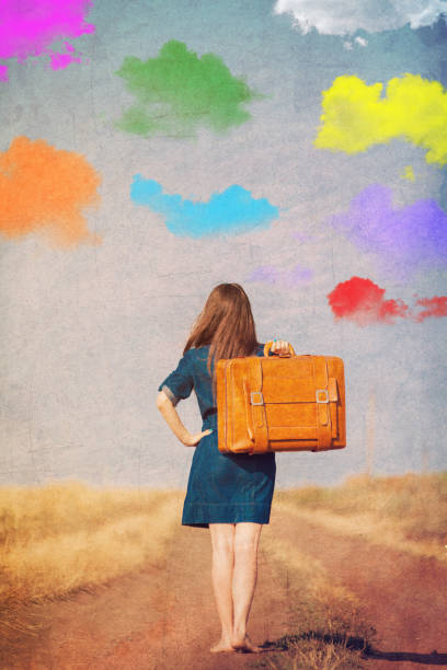 istock girl with suitcase walking on the road 928772196