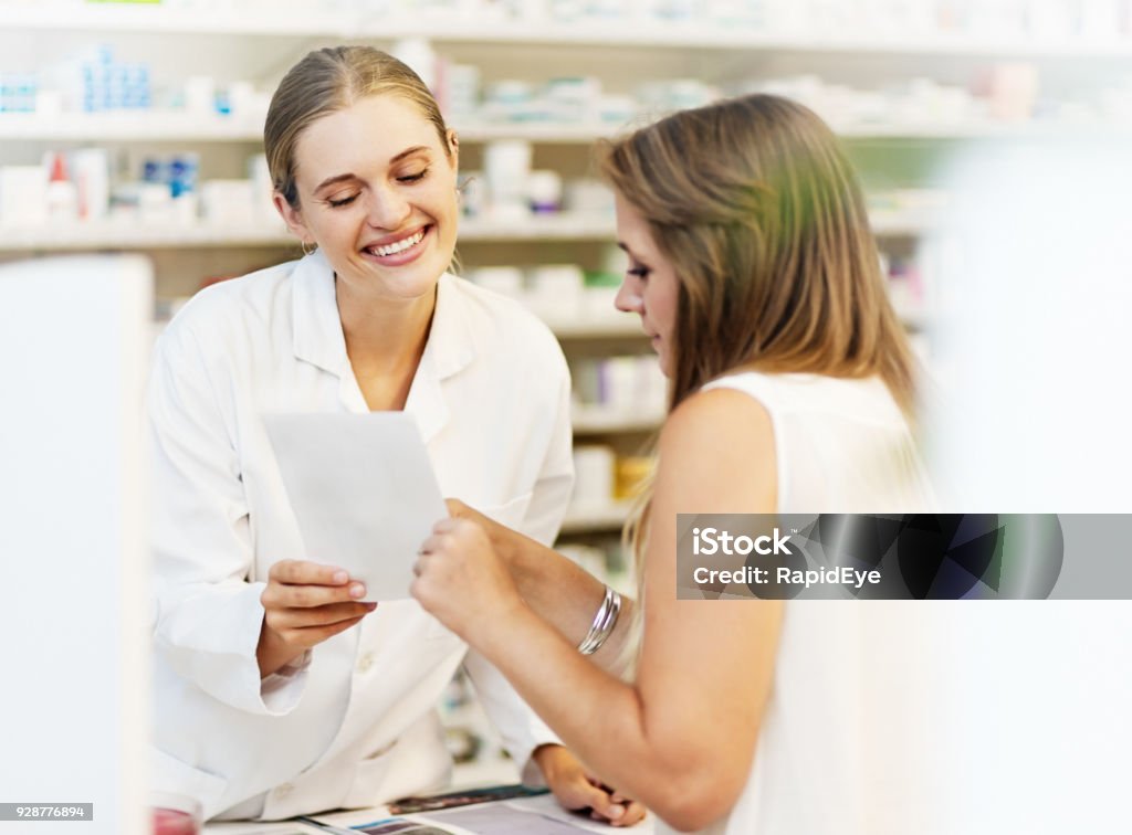 Pharmacien de femme souriant bavarde pour clientèle féminine sur les médicaments - Photo de Pharmacien libre de droits